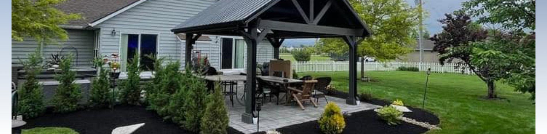 A finished Ben's Landscaping pavilion, paver patio and fresh mulch beds in Delaware County