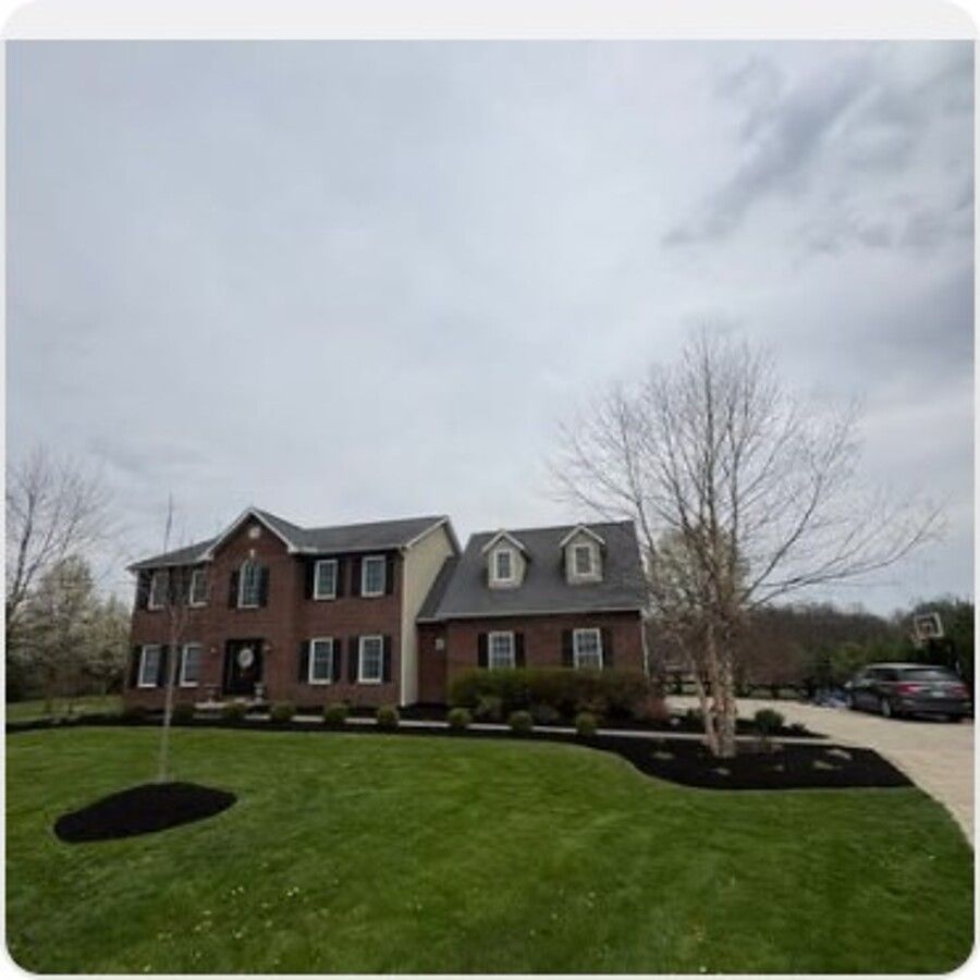 Manicured mulch bed at a brick colonial home
